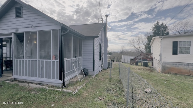 view of home's exterior with a yard and a sunroom