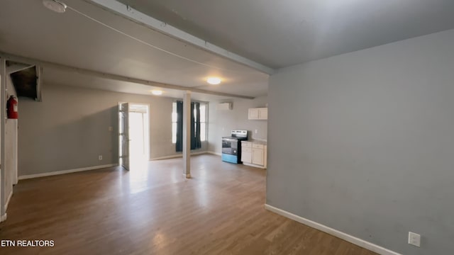 unfurnished living room featuring beamed ceiling and light hardwood / wood-style floors