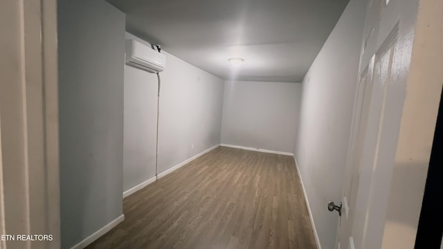 spare room featuring dark hardwood / wood-style flooring and a wall mounted air conditioner