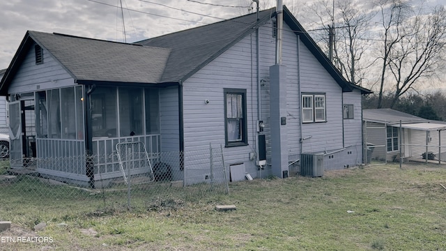 view of side of home with cooling unit, a lawn, and a sunroom