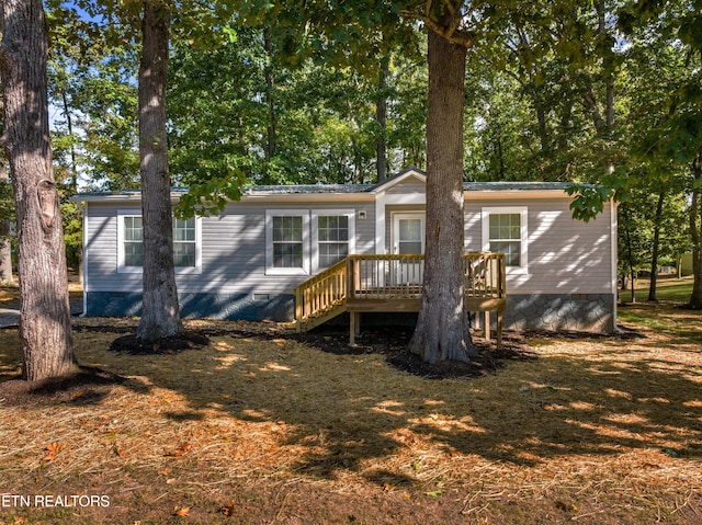 rear view of property featuring a yard and a deck