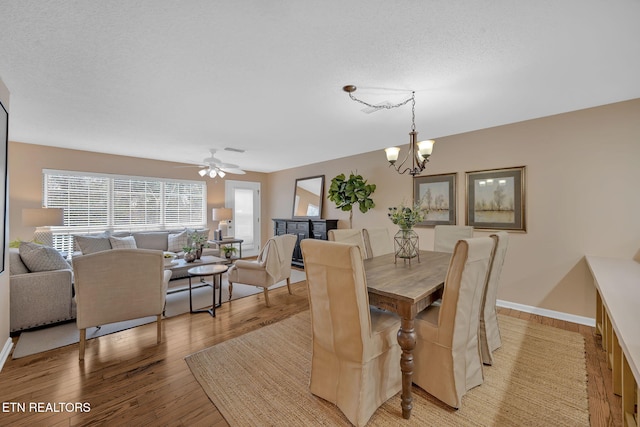 dining space featuring ceiling fan with notable chandelier, light hardwood / wood-style floors, and a textured ceiling