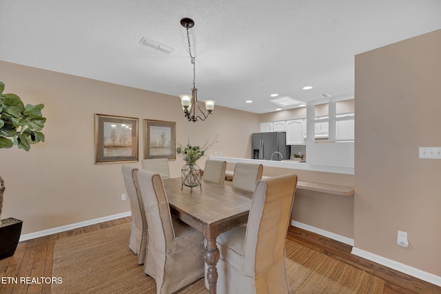 dining area with a chandelier and light wood-type flooring