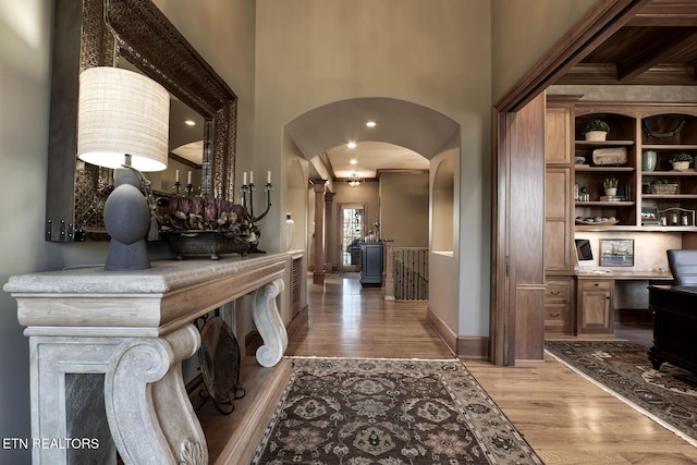 corridor featuring a towering ceiling and light hardwood / wood-style flooring