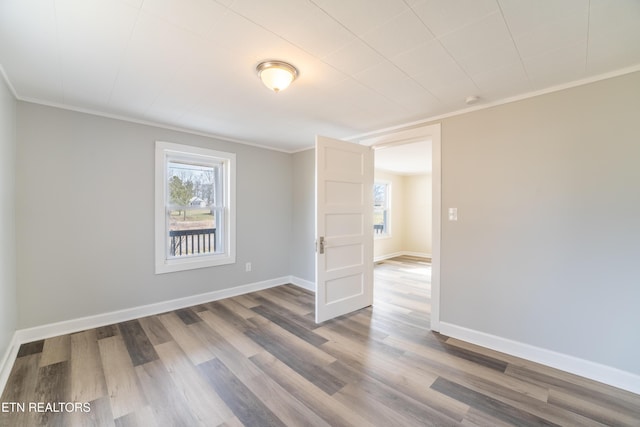 empty room with hardwood / wood-style flooring and ornamental molding