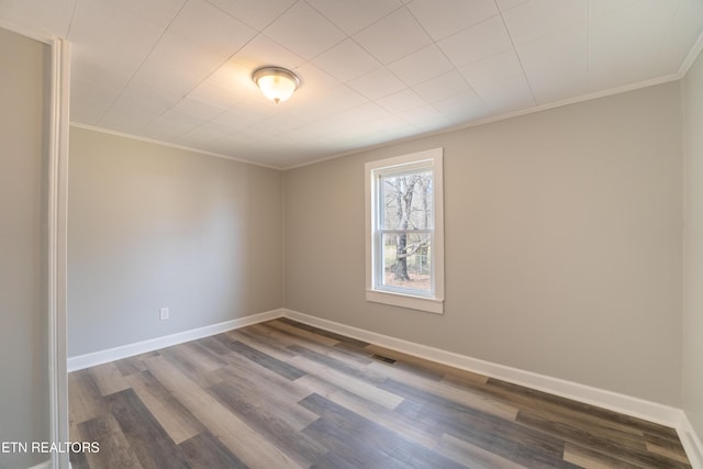 spare room with ornamental molding and hardwood / wood-style floors