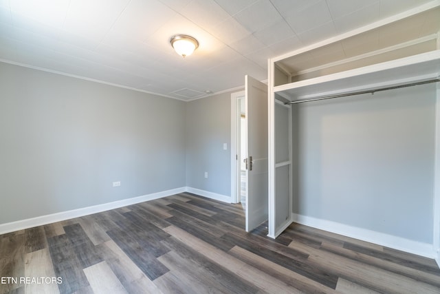 unfurnished bedroom featuring dark hardwood / wood-style flooring and a closet