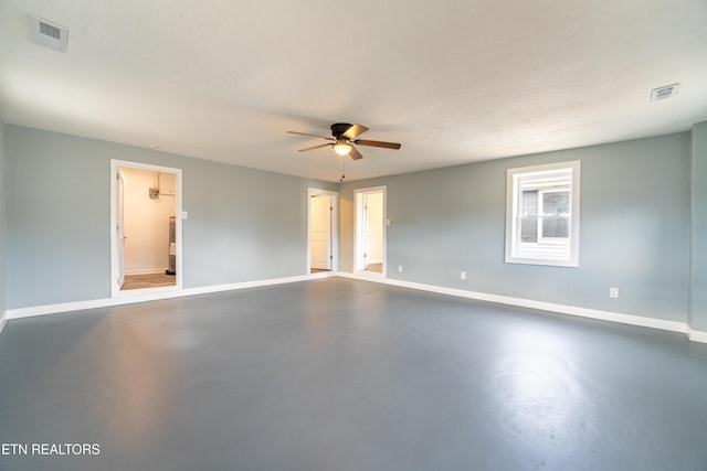 empty room with ceiling fan and concrete flooring