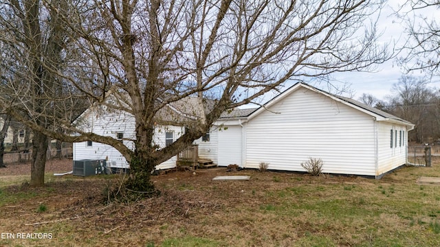 view of side of home featuring a yard and central AC unit