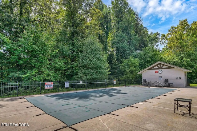 view of pool featuring an outbuilding and a patio