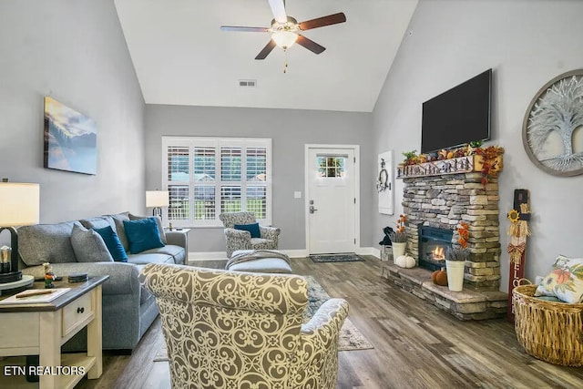 living room featuring hardwood / wood-style flooring, a fireplace, high vaulted ceiling, and ceiling fan