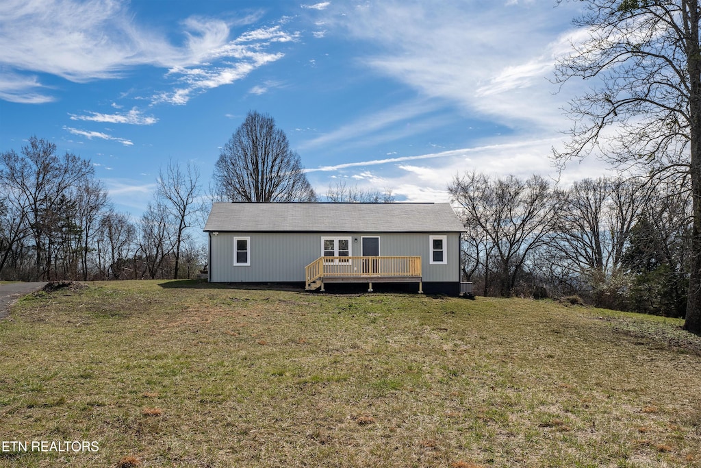 view of front of home featuring a wooden deck and a front lawn