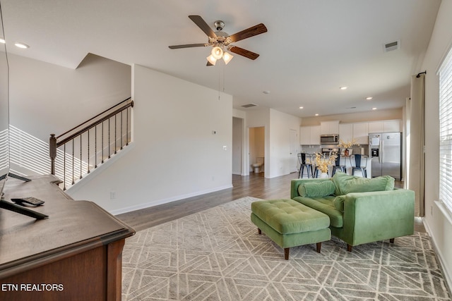 living room featuring hardwood / wood-style floors and ceiling fan