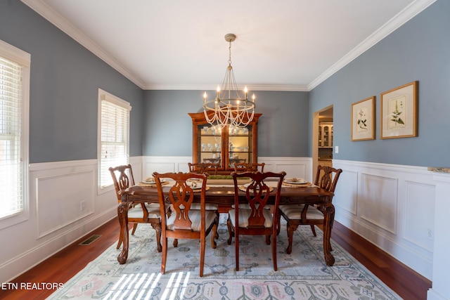 dining room featuring crown molding, hardwood / wood-style floors, and a notable chandelier