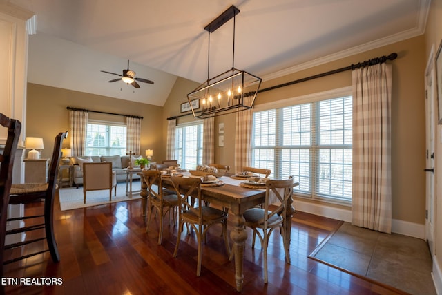 dining room featuring ceiling fan with notable chandelier, ornamental molding, dark hardwood / wood-style flooring, and vaulted ceiling