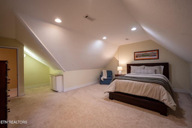 bedroom featuring light colored carpet and vaulted ceiling