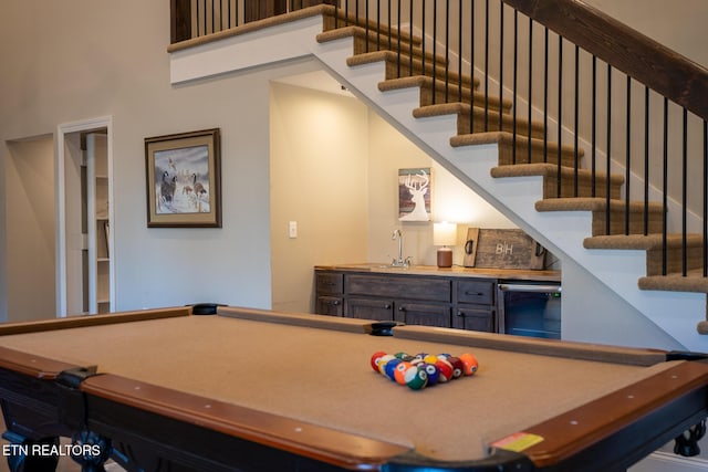 game room with billiards, indoor wet bar, and a high ceiling