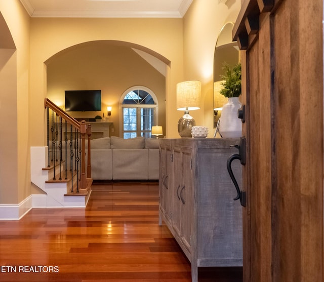 foyer featuring wood-type flooring and ornamental molding