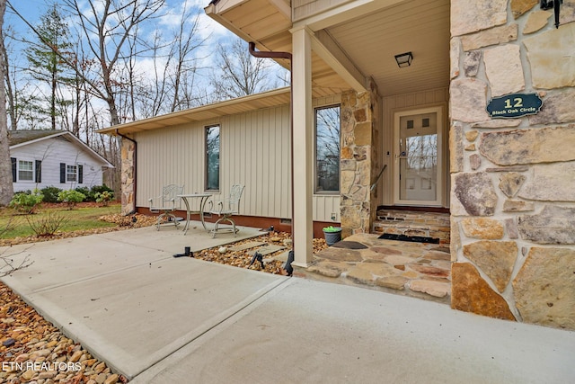 property entrance featuring stone siding and a patio area