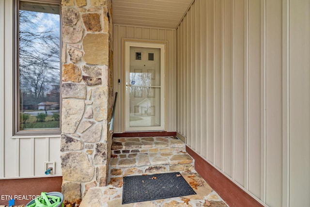 property entrance with stone siding and board and batten siding