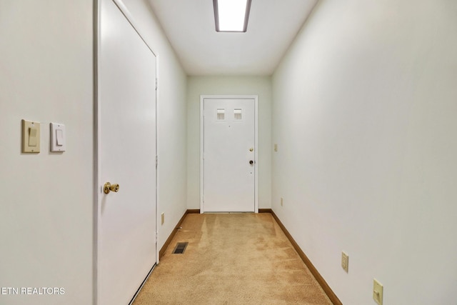 doorway to outside with baseboards, visible vents, and light colored carpet