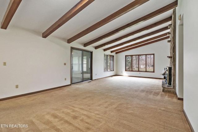 unfurnished living room with lofted ceiling with beams, baseboards, and light colored carpet