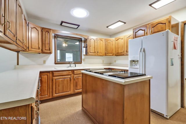 kitchen with a center island, white refrigerator with ice dispenser, light countertops, brown cabinetry, and a sink