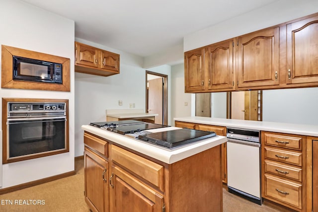 kitchen featuring brown cabinets, a center island, a peninsula, light countertops, and black appliances