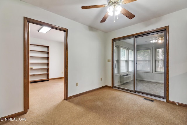 empty room with light carpet, baseboards, visible vents, a ceiling fan, and cooling unit