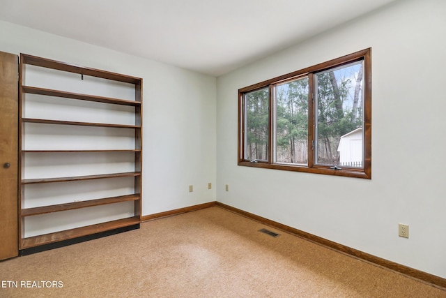 unfurnished bedroom featuring carpet, visible vents, and baseboards