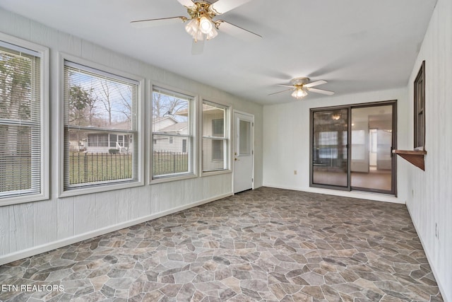 unfurnished sunroom featuring a ceiling fan