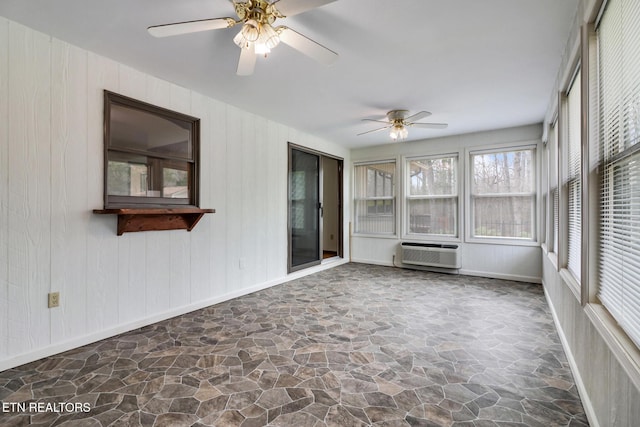 unfurnished sunroom featuring a ceiling fan and a wall mounted AC