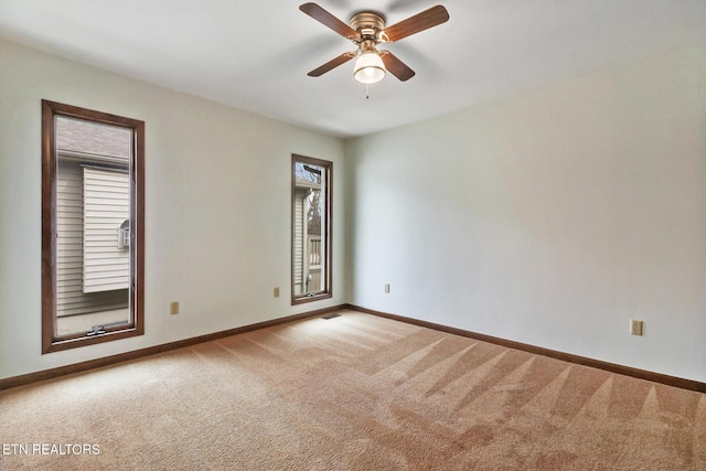 spare room with ceiling fan, carpet floors, and baseboards