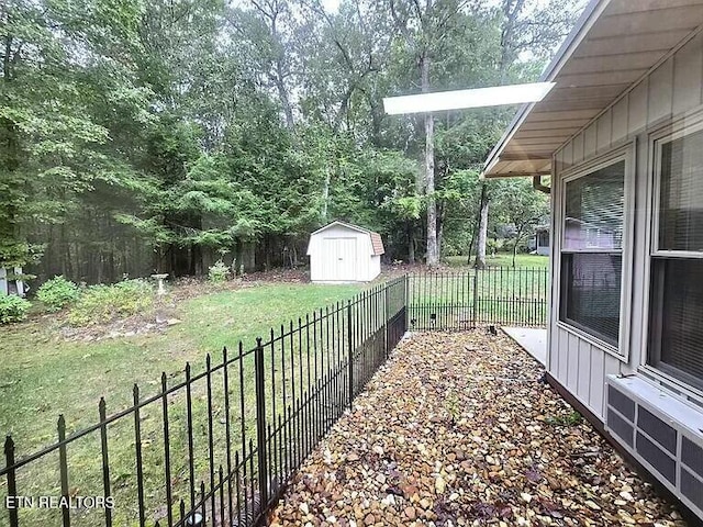 view of yard featuring a fenced backyard, an outdoor structure, and a storage unit