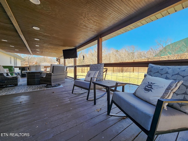 wooden deck featuring outdoor lounge area and fence