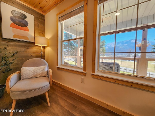 sitting room featuring wood ceiling, wood finished floors, baseboards, and wood walls