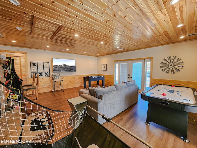 living room with wooden walls, wainscoting, wood ceiling, and wood finished floors