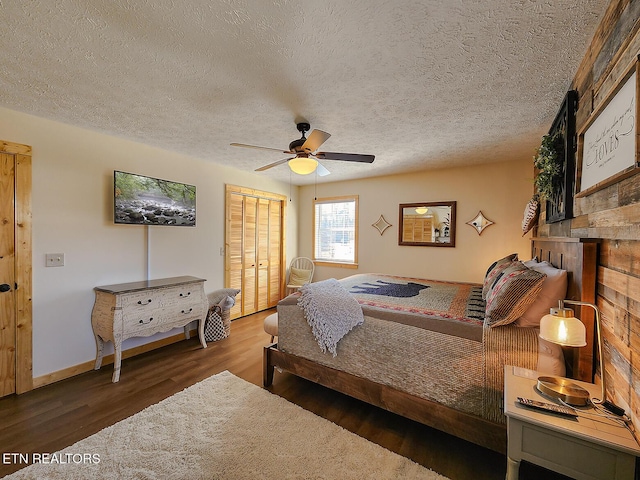 bedroom with a ceiling fan, wood finished floors, a closet, and a textured ceiling