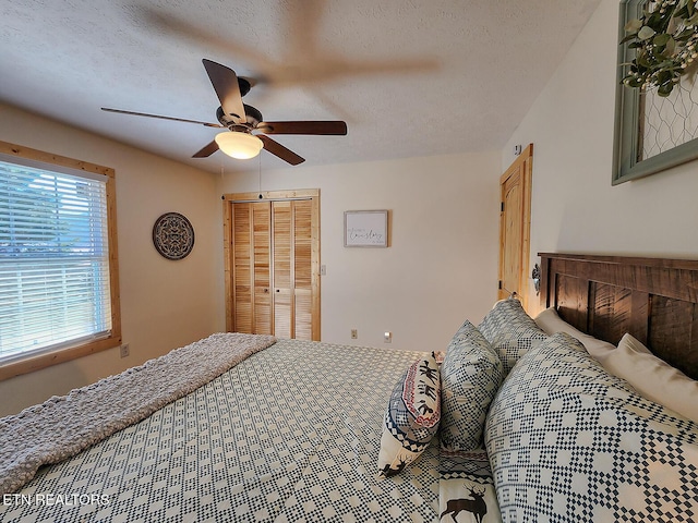 bedroom with a ceiling fan, a closet, and a textured ceiling