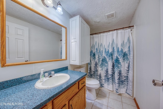 bathroom featuring vanity, tile patterned floors, a textured ceiling, and toilet