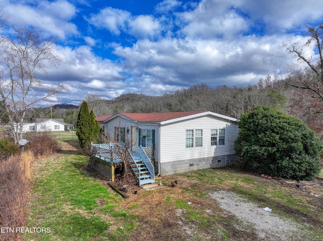 view of front facade featuring a front yard and a deck