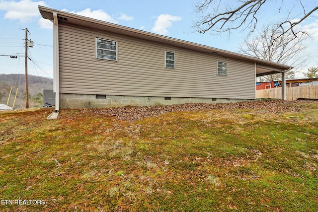 view of side of home featuring a yard and central AC