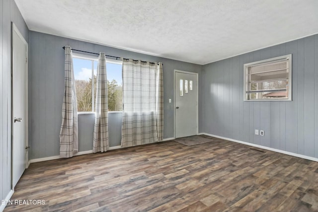 unfurnished room featuring dark hardwood / wood-style flooring and a textured ceiling