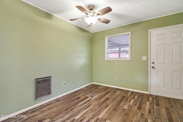 empty room with ceiling fan, ornamental molding, dark hardwood / wood-style flooring, and heating unit