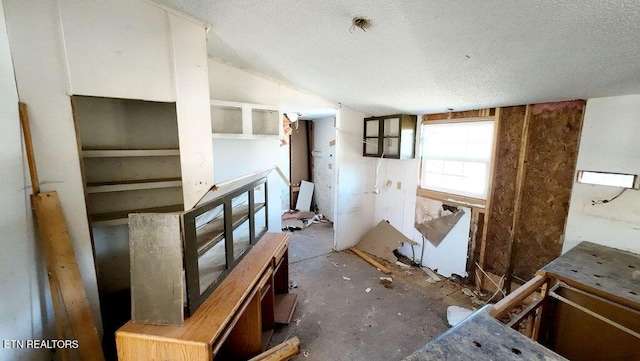 interior space featuring vaulted ceiling and a textured ceiling