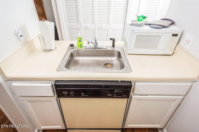 room details with white cabinetry, white appliances, light countertops, and a sink