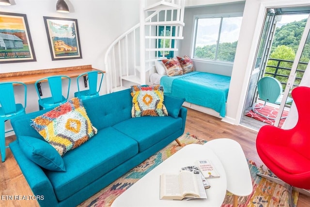 living room with stairway, baseboards, and wood finished floors