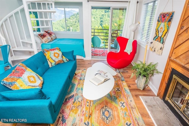 living area with a fireplace, baseboards, and wood finished floors