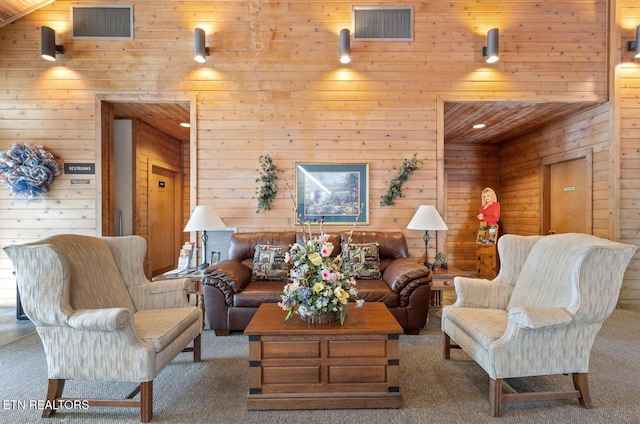 carpeted living area featuring wood walls and visible vents