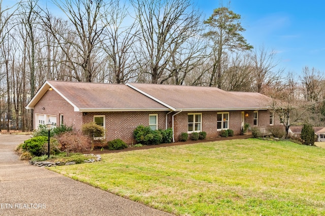 single story home featuring a front lawn and a garage